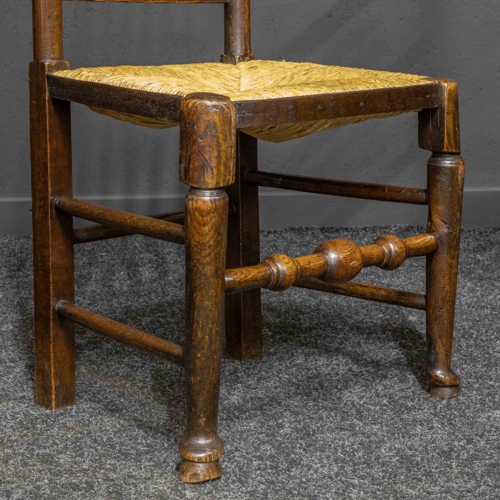 A set of eight dark oak Lancashire spindleback dining chairs with hand-woven rush seats, comprising six side chairs and two carver armchairs. View II