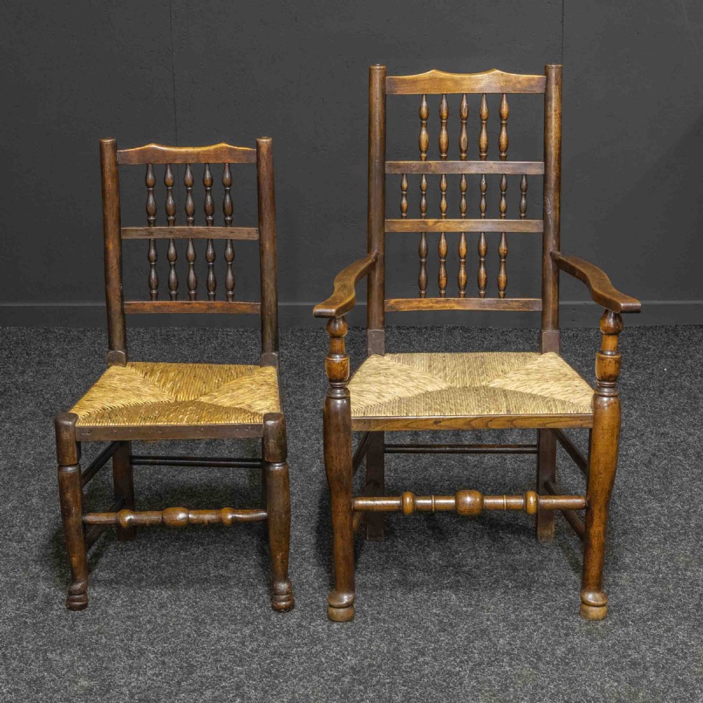 A set of eight dark oak Lancashire spindleback dining chairs with hand-woven rush seats, comprising six side chairs and two carver armchairs. View IV