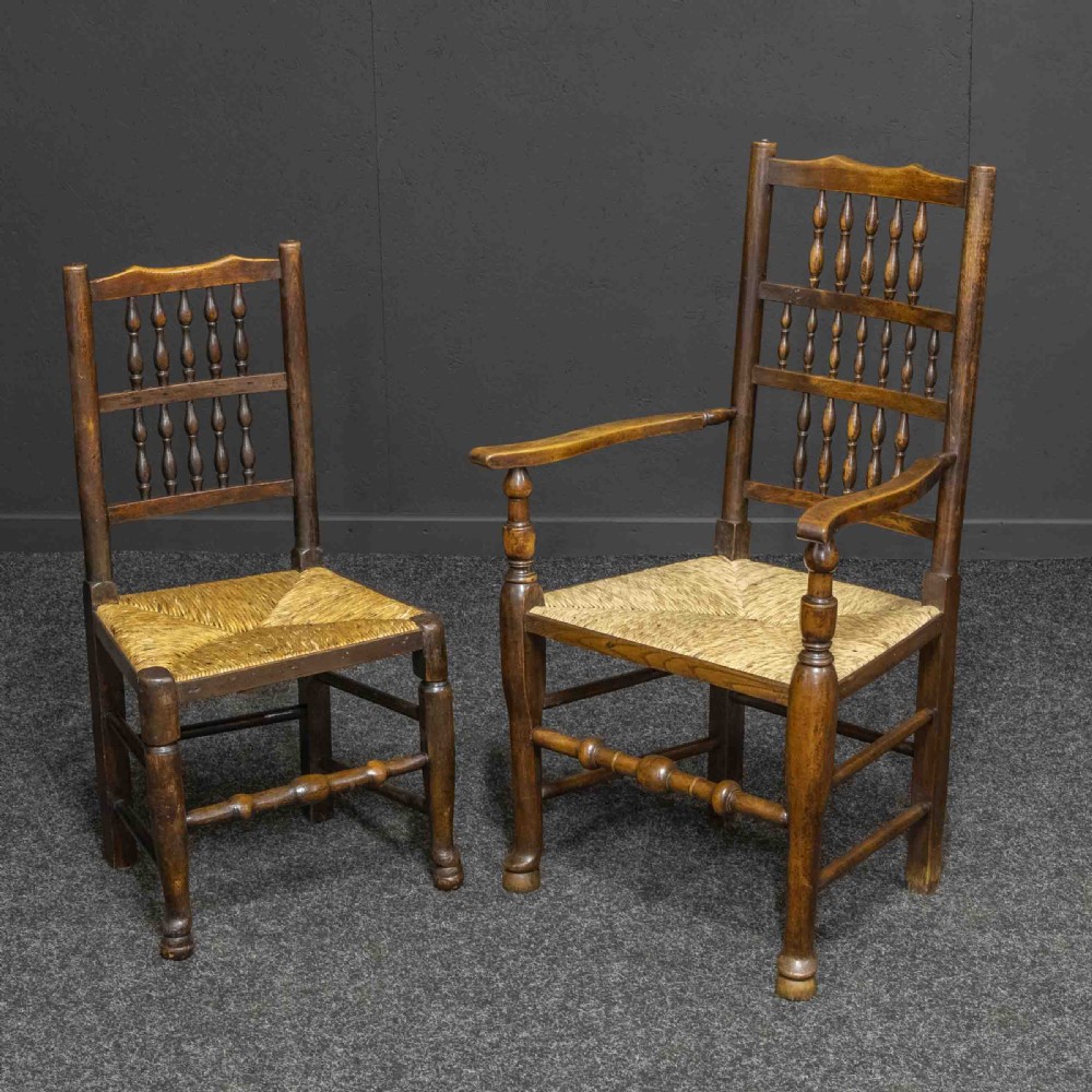 A set of eight dark oak Lancashire spindleback dining chairs with hand-woven rush seats, comprising six side chairs and two carver armchairs. View V