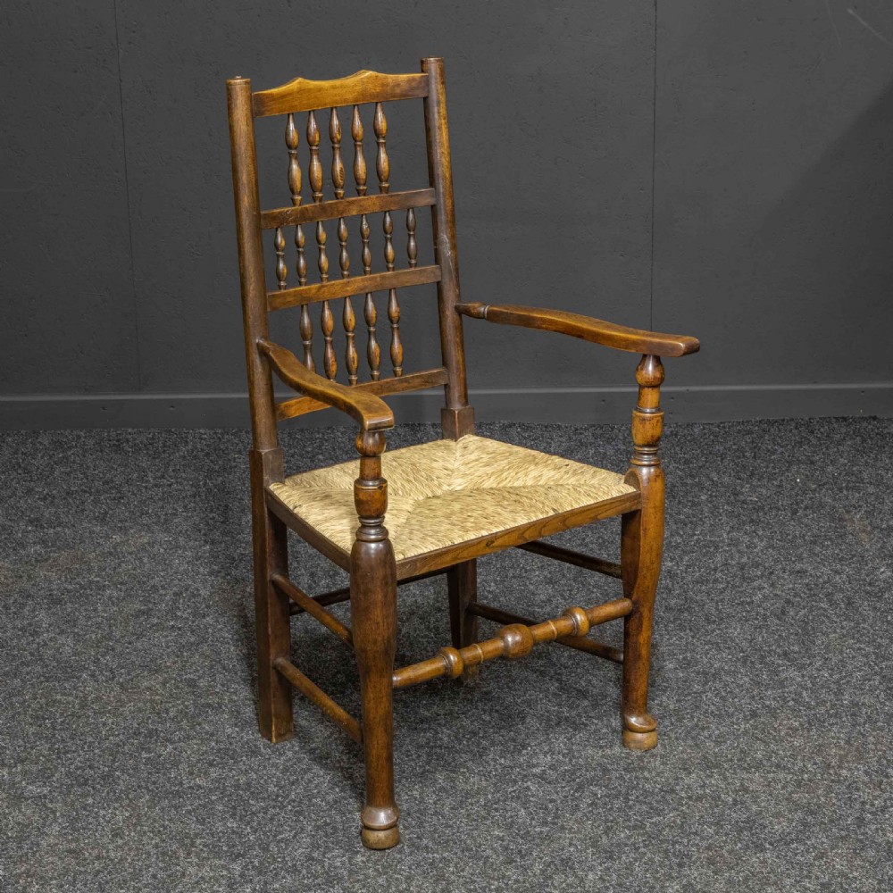 A set of eight dark oak Lancashire spindleback dining chairs with hand-woven rush seats, comprising six side chairs and two carver armchairs. View VI