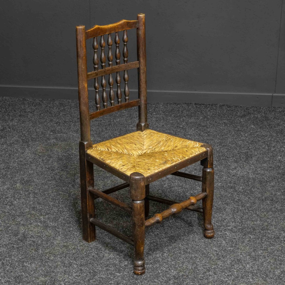 A set of eight dark oak Lancashire spindleback dining chairs with hand-woven rush seats, comprising six side chairs and two carver armchairs. View VIII