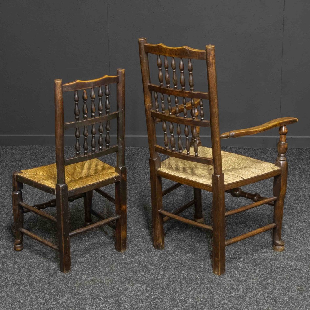 A set of eight dark oak Lancashire spindleback dining chairs with hand-woven rush seats, comprising six side chairs and two carver armchairs. View XI