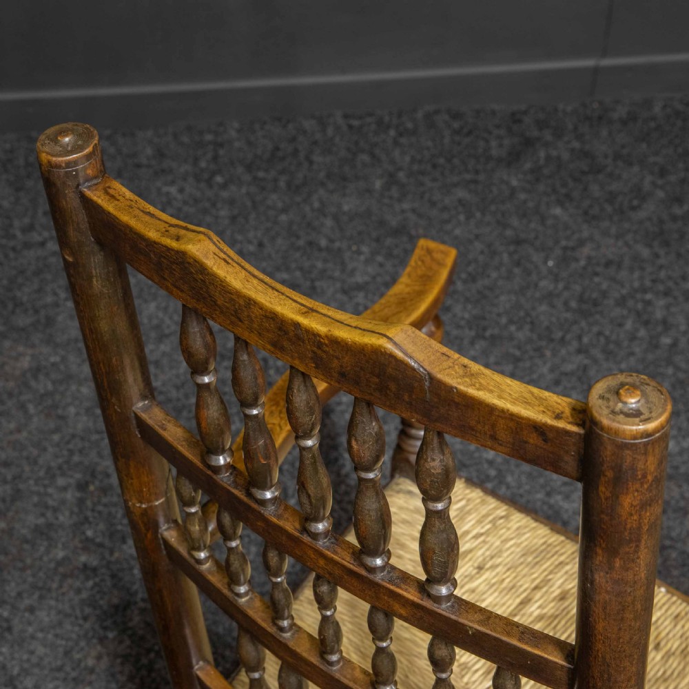A set of eight dark oak Lancashire spindleback dining chairs with hand-woven rush seats, comprising six side chairs and two carver armchairs. View XII