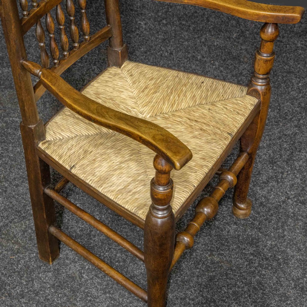 A set of eight dark oak Lancashire spindleback dining chairs with hand-woven rush seats, comprising six side chairs and two carver armchairs. View XIII