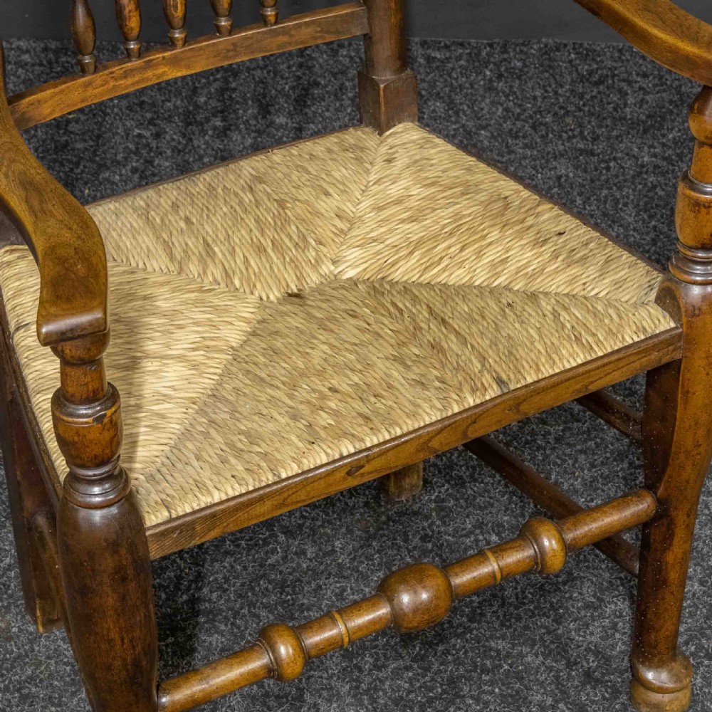 A set of eight dark oak Lancashire spindleback dining chairs with hand-woven rush seats, comprising six side chairs and two carver armchairs. View XIV