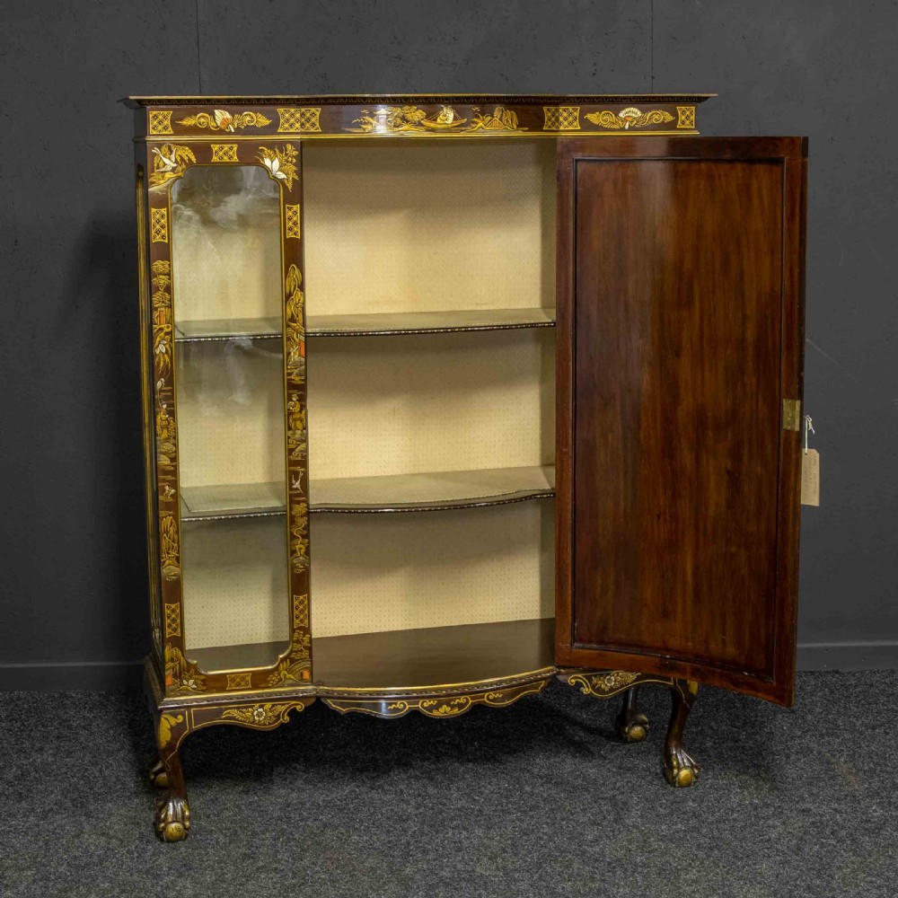 An antique dark timber Chinoiserie display cabinet featuring gold lacquered oriental scenes, glazed side panels, and carved cabriole legs with ball and claw feet. View II