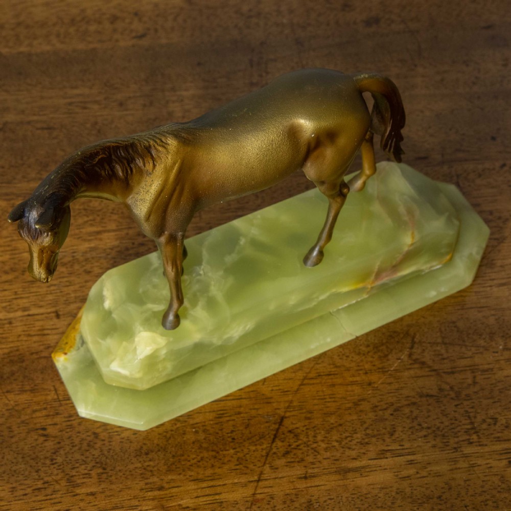 A patinated bronze stallion sculpture resting on a faceted pale green onyx base. View VI