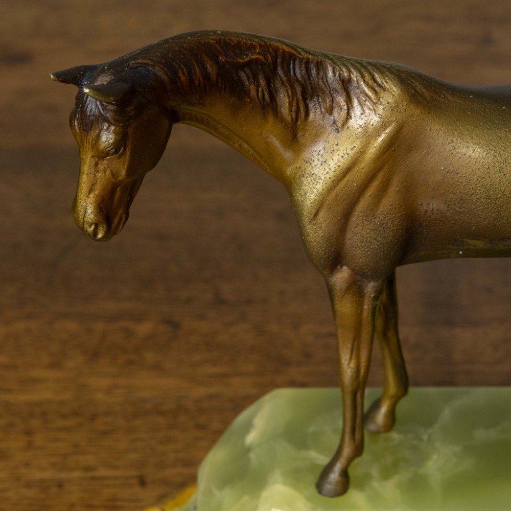 A patinated bronze stallion sculpture resting on a faceted pale green onyx base. View VII