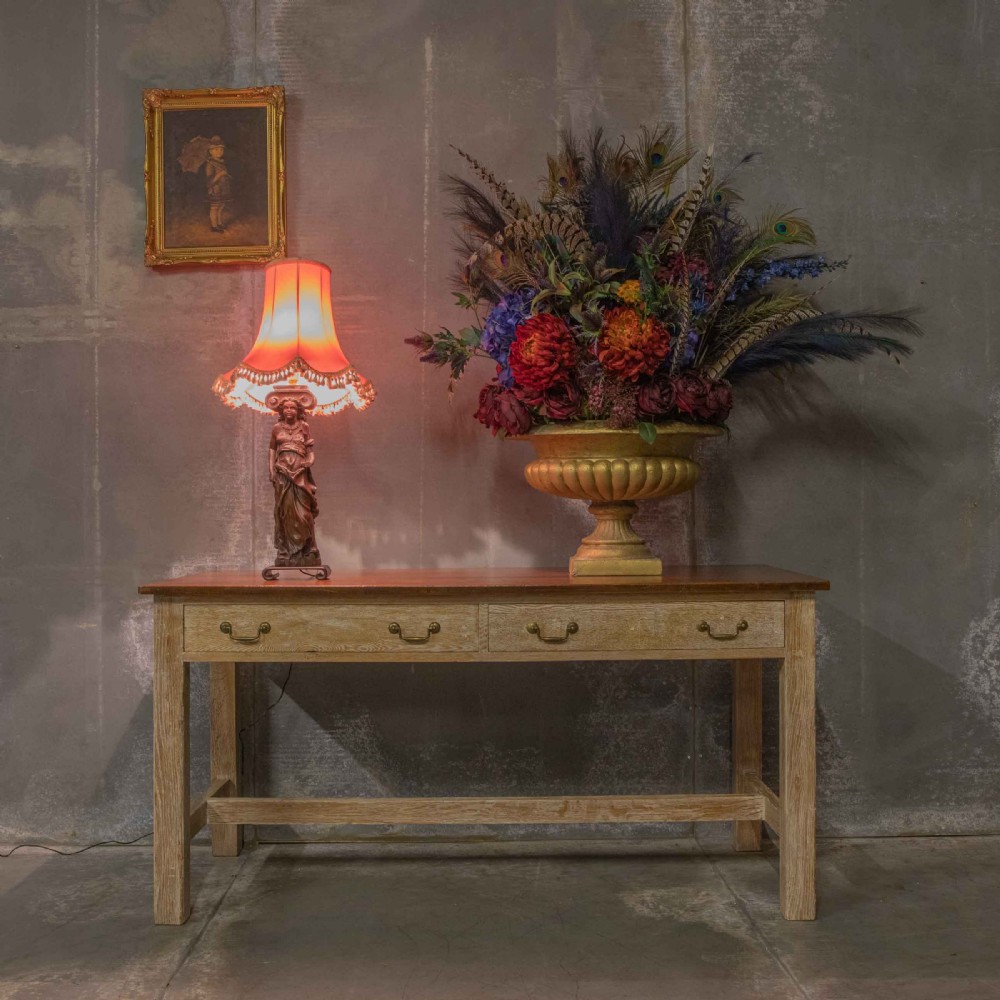 A hand-carved dark oak female caryatid figure mounted on a scroll base and converted into a table lamp with a fringed lampshade. View VIII