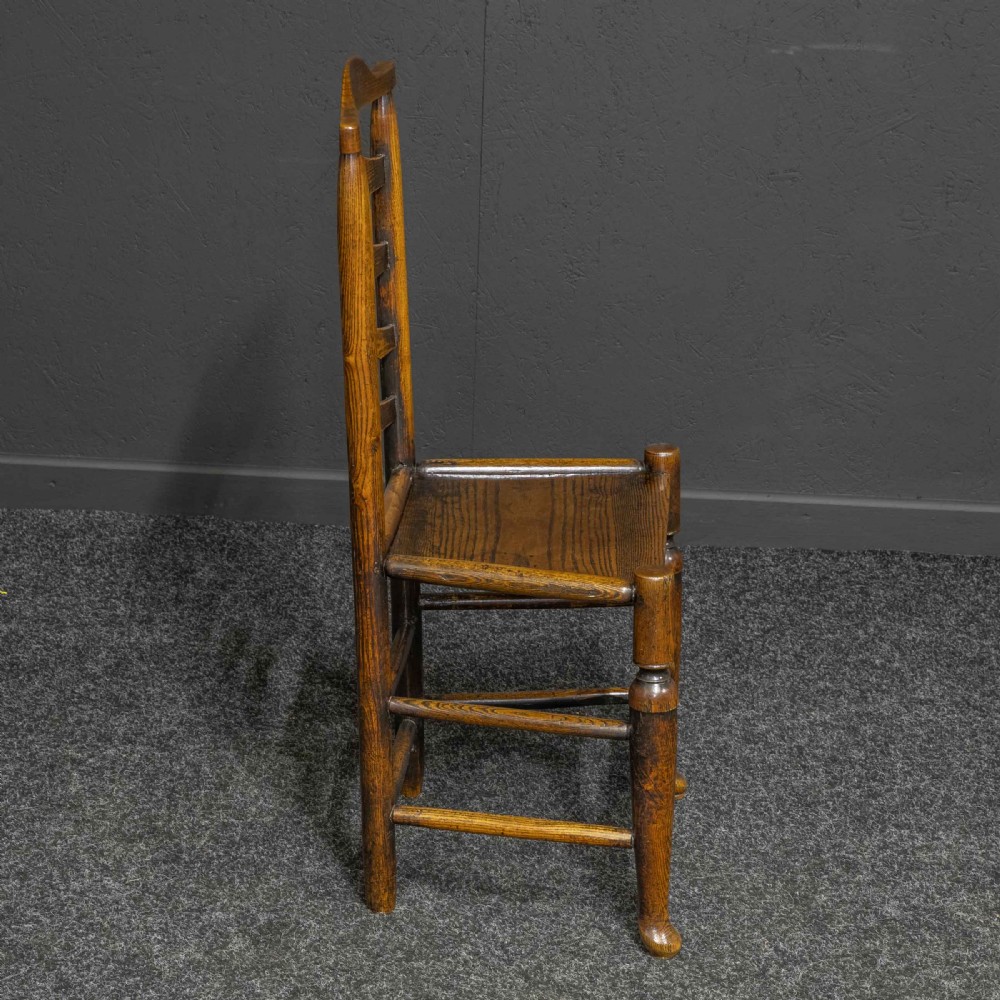 A set of eight Georgian oak dining chairs featuring wavy ladderback splats, solid wooden seats, and turned front stretchers. View VII