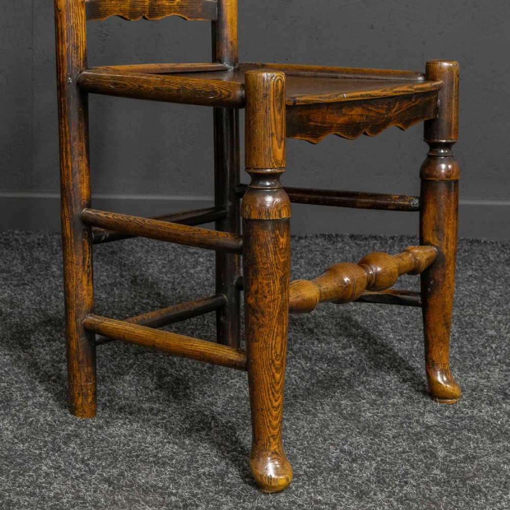 A set of eight Georgian oak dining chairs featuring wavy ladderback splats, solid wooden seats, and turned front stretchers. View X