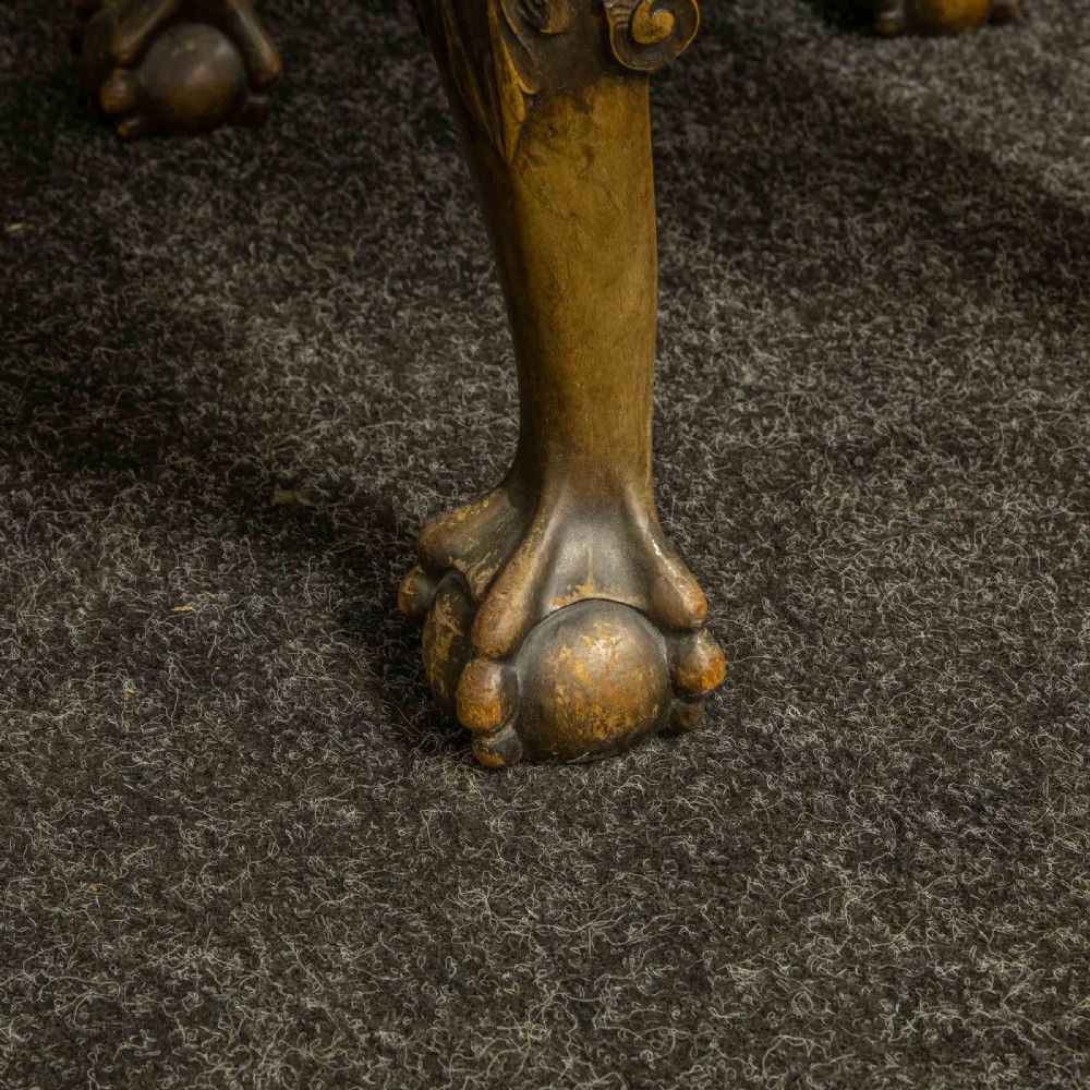 A low Chippendale style stool featuring a brown leather upholstered seat with brass stud detailing and dark carved cabriole legs ending in claw and ball feet. View IX
