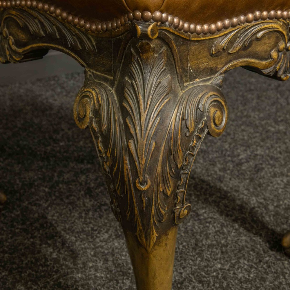 A low Chippendale style stool featuring a brown leather upholstered seat with brass stud detailing and dark carved cabriole legs ending in claw and ball feet. View XI