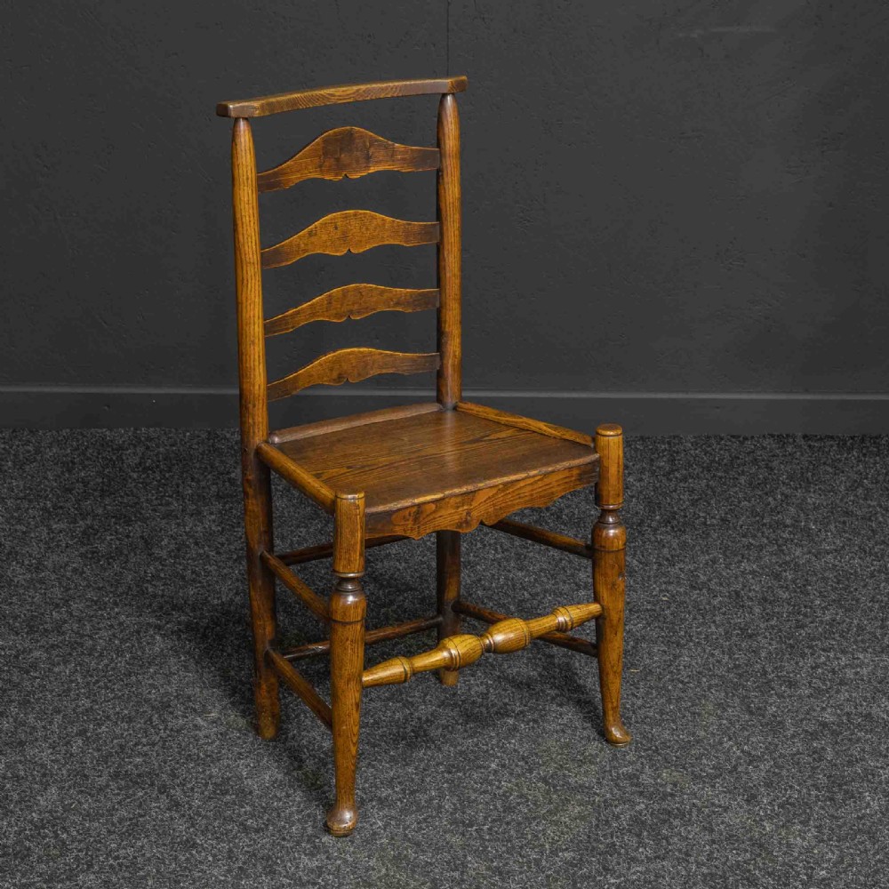 A set of eight Georgian oak dining chairs featuring wavy ladderbacks, solid panel seats, and turned front stretchers. View II