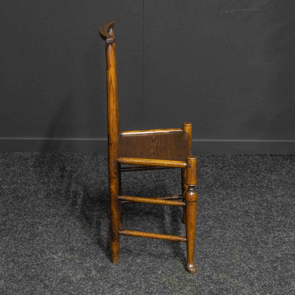 A set of eight Georgian oak dining chairs featuring wavy ladderbacks, solid panel seats, and turned front stretchers. View III