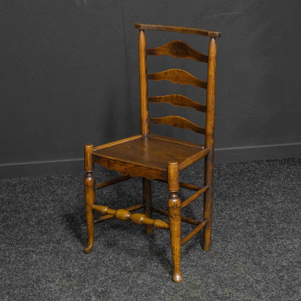 A set of eight Georgian oak dining chairs featuring wavy ladderbacks, solid panel seats, and turned front stretchers. View IV