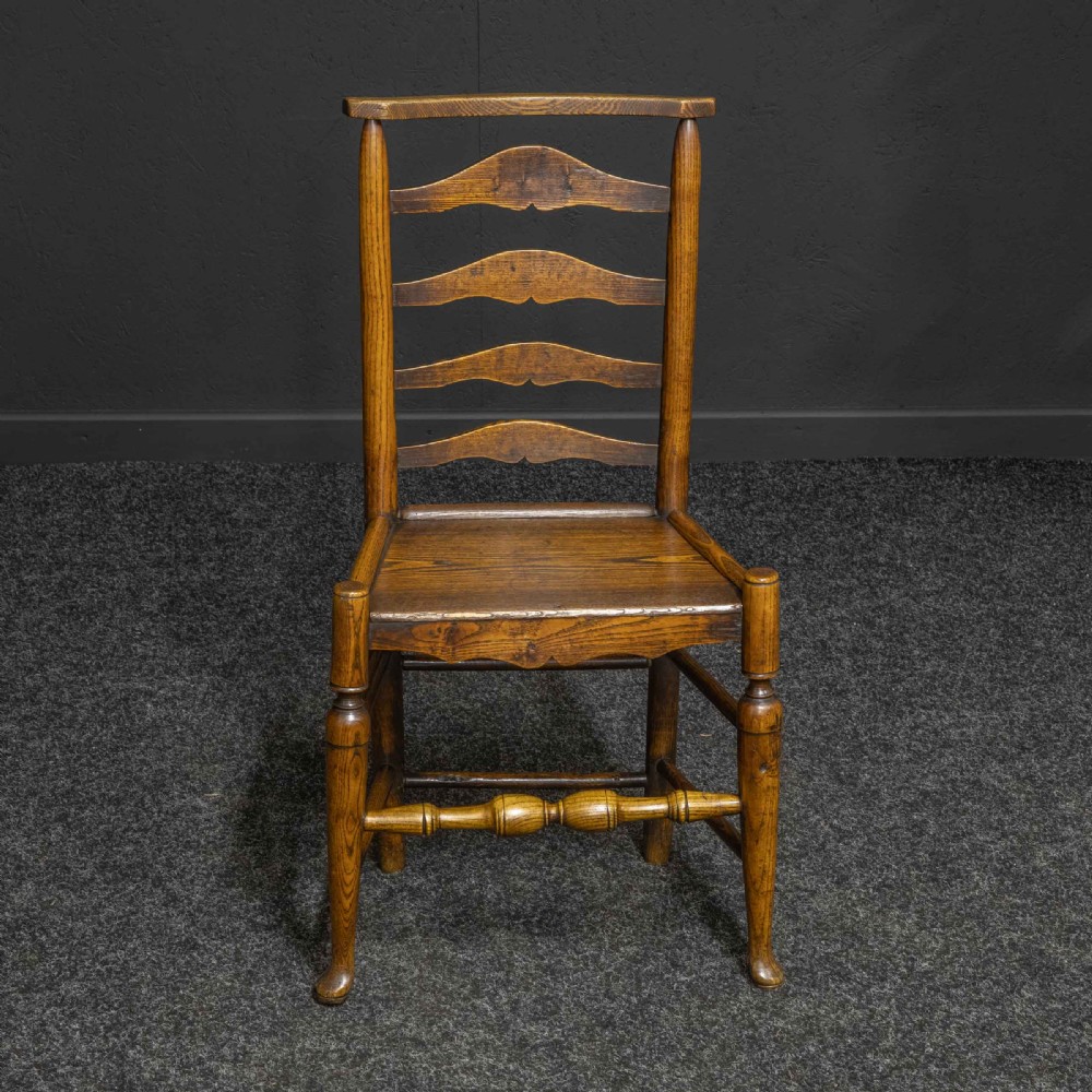 A set of eight Georgian oak dining chairs featuring wavy ladderbacks, solid panel seats, and turned front stretchers. View VI