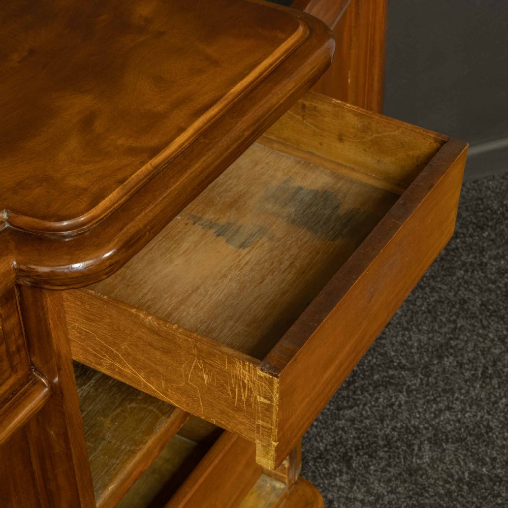 A Victorian mahogany sideboard featuring a carved backboard gallery, flame mahogany panelled doors, a central drawer, and a plinth base. View VII