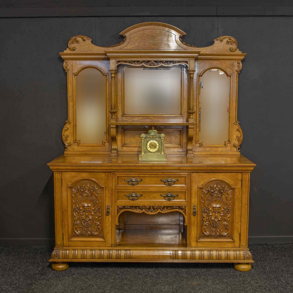 Victorian pollard oak sideboard featuring a carved mirror-back superstructure, two central drawers, an open lower shelf, and flanking relief-carved cupboard doors. View II