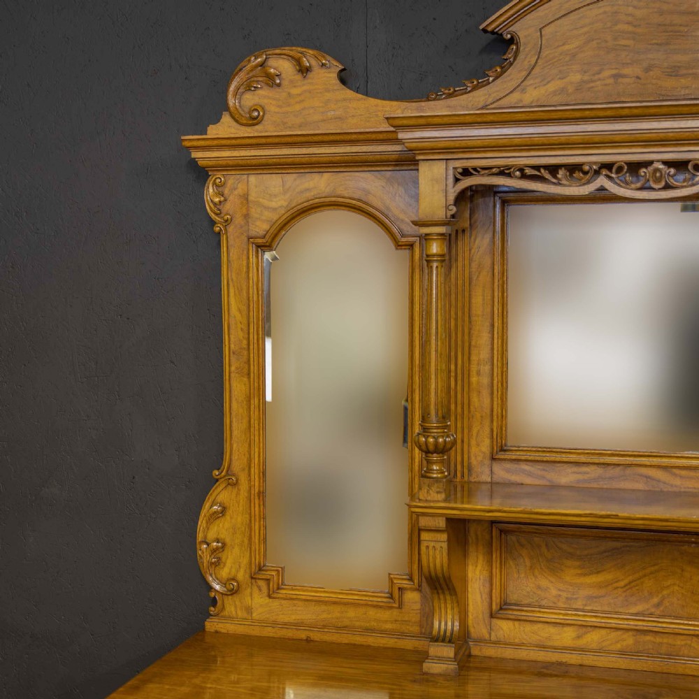 Victorian pollard oak sideboard featuring a carved mirror-back superstructure, two central drawers, an open lower shelf, and flanking relief-carved cupboard doors. View X