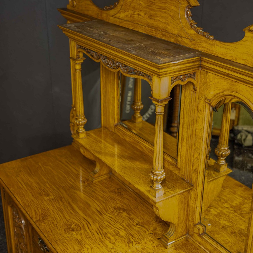 Victorian pollard oak sideboard featuring a carved mirror-back superstructure, two central drawers, an open lower shelf, and flanking relief-carved cupboard doors. View XV