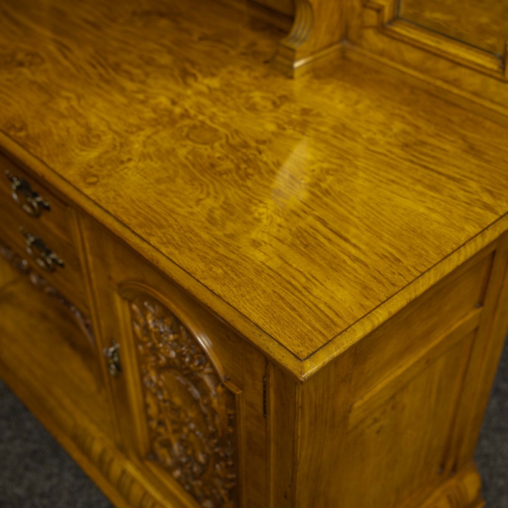 Victorian pollard oak sideboard featuring a carved mirror-back superstructure, two central drawers, an open lower shelf, and flanking relief-carved cupboard doors. View XVI