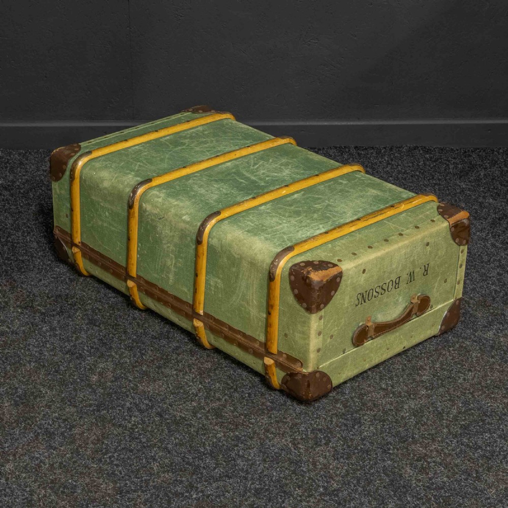An olive green canvas-covered steamer trunk featuring wooden bentwood slats, leather corner protectors, leather side handles, and stencilled black lettering. View III