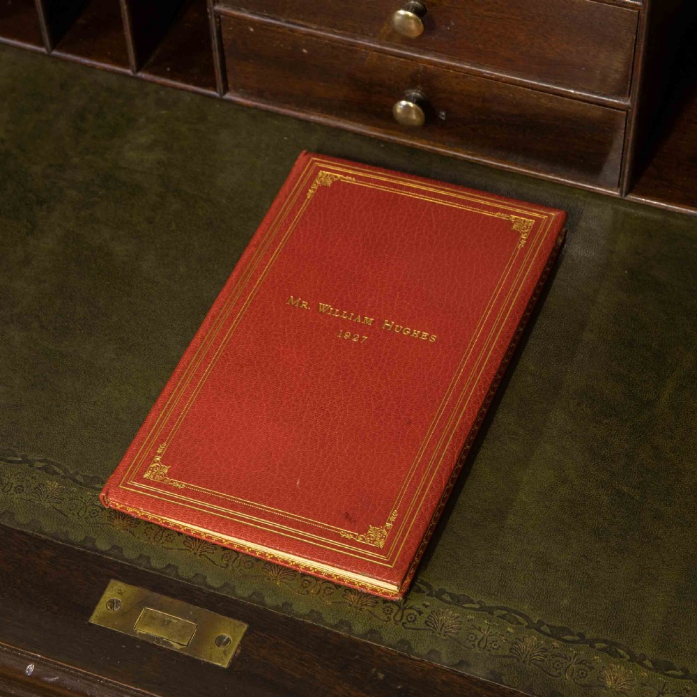 An early 20th-century Chippendale style dark mahogany roll-top desk featuring a green leather writing surface, fitted interior pigeonholes, twin drawer pedestals, and brass drop handles. View VII