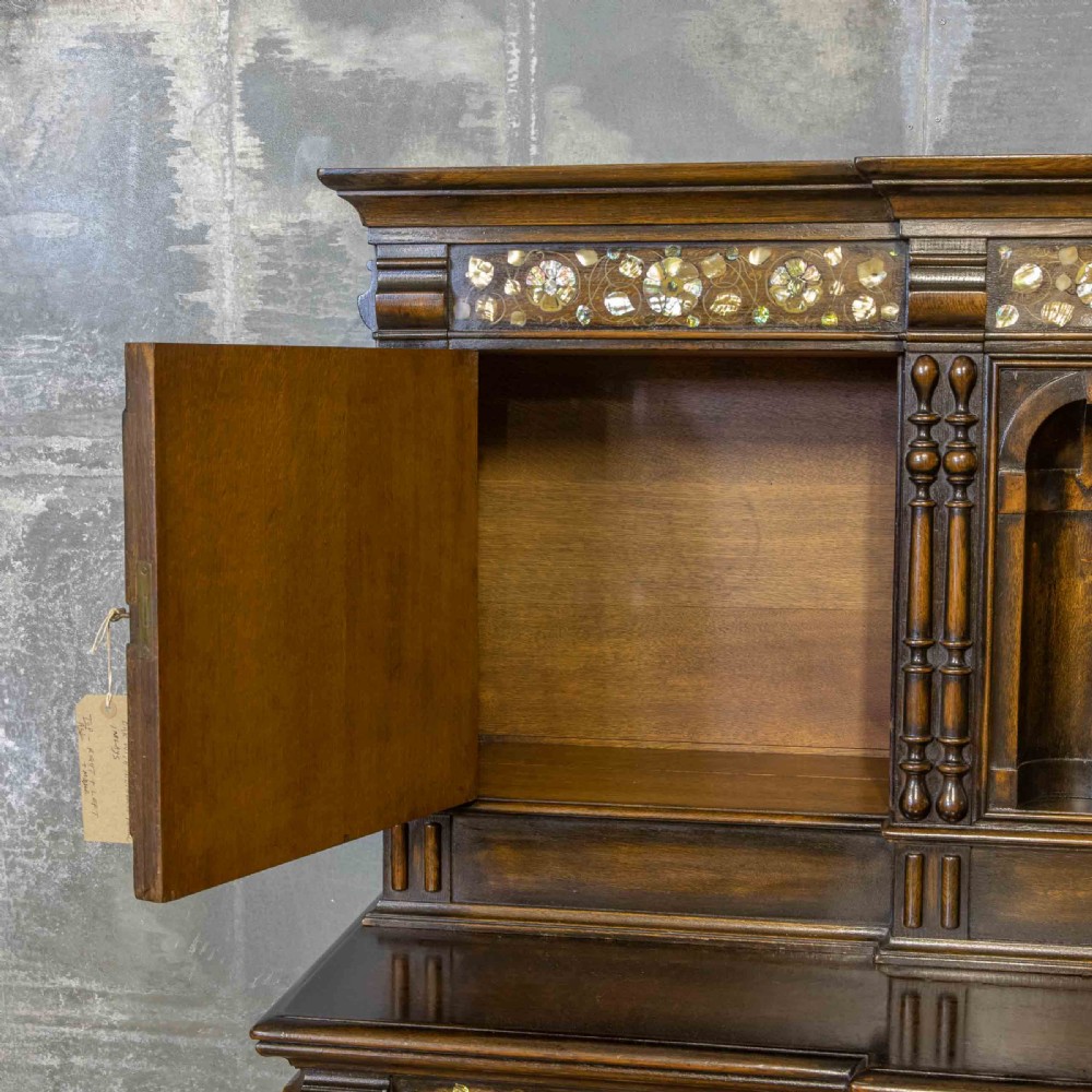 A dark oak Jacobean dresser featuring geometric mouldings, mother-of-pearl inlays, arched panels, turned split spindles, and lower drawers. View III