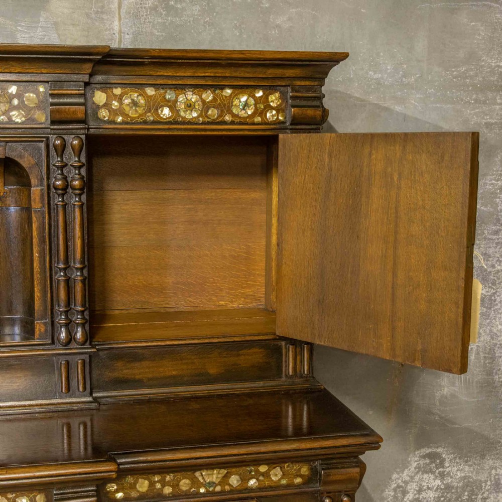 A dark oak Jacobean dresser featuring geometric mouldings, mother-of-pearl inlays, arched panels, turned split spindles, and lower drawers. View VIII