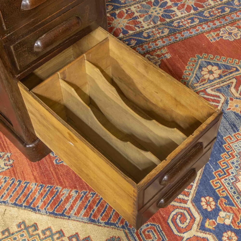 A late Victorian oak roll-top desk with an open tambour shutter revealing internal pigeonholes above a twin-pedestal base with wooden handles. View VIII