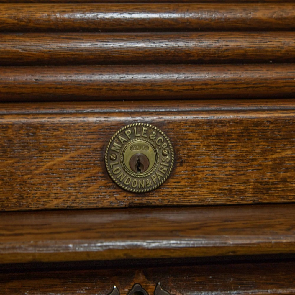 An Edwardian oak roll top desk with a raised slatted tambour front revealing fitted interior compartments above twin pedestal drawers. View IX