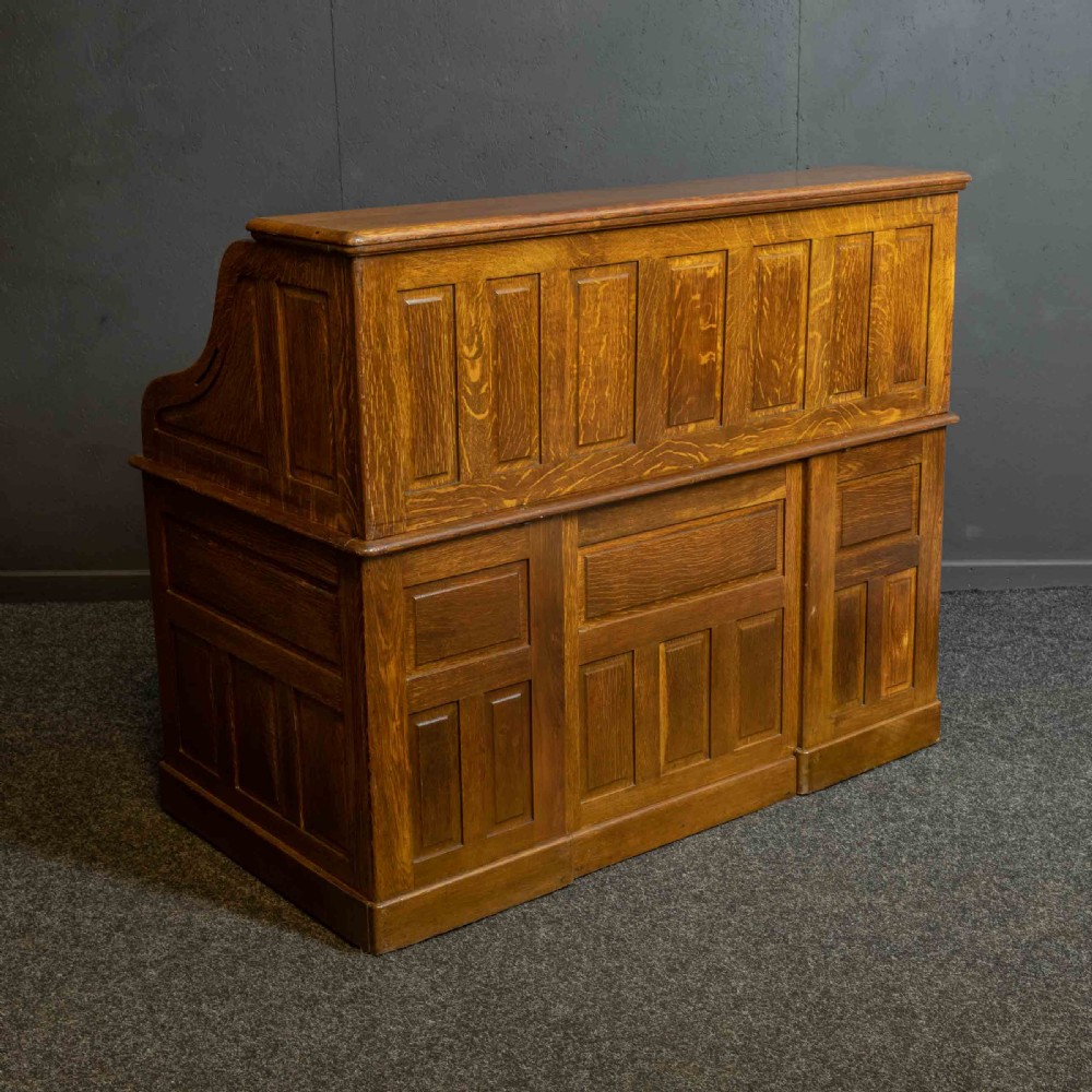 An Edwardian oak roll top desk with a raised slatted tambour front revealing fitted interior compartments above twin pedestal drawers. View XV