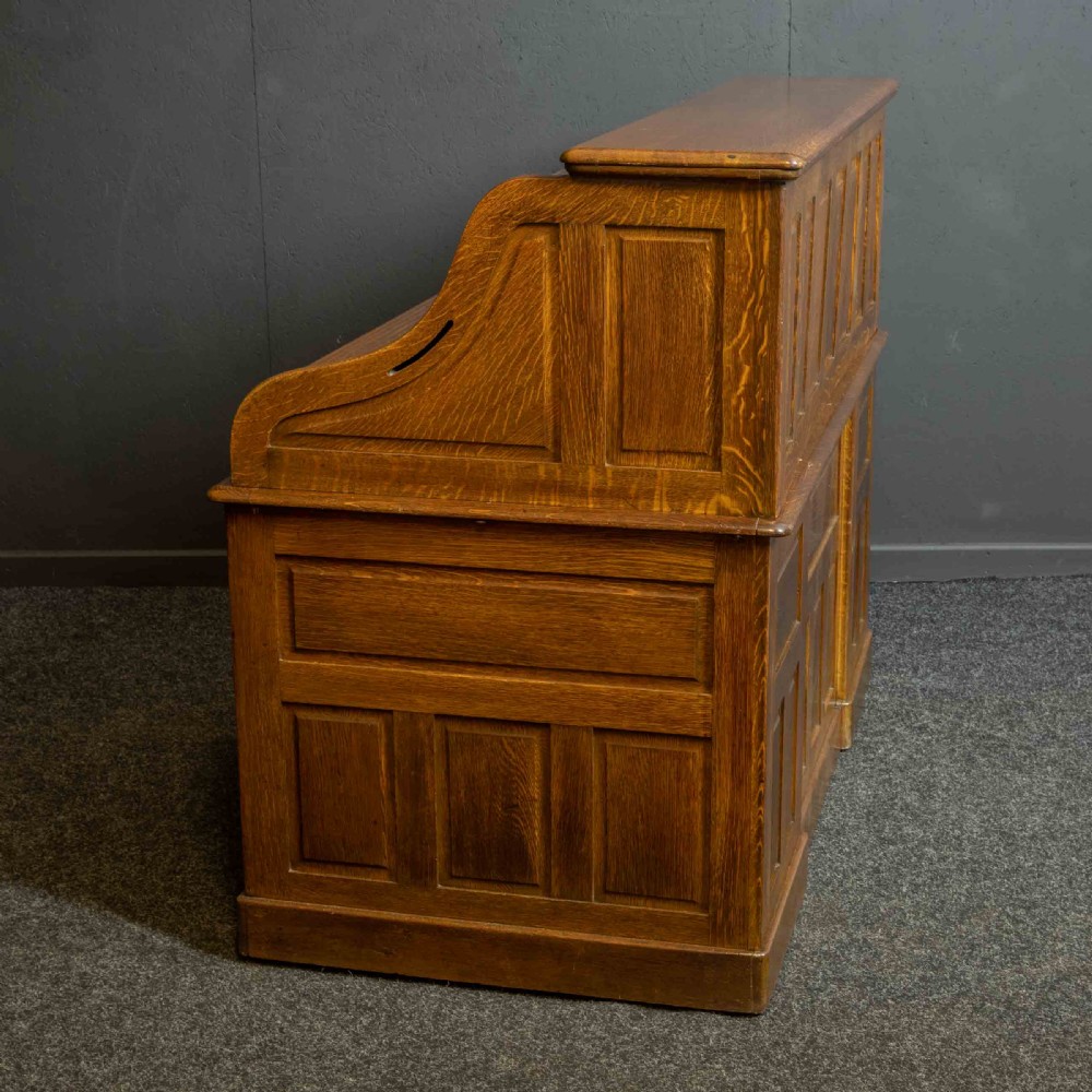 An Edwardian oak roll top desk with a raised slatted tambour front revealing fitted interior compartments above twin pedestal drawers. View XVI