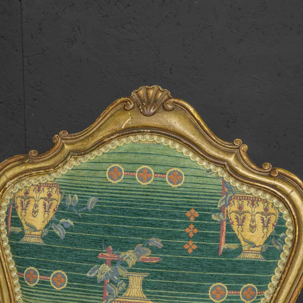 A 19th-century French giltwood fauteuil open armchair featuring carved shell motifs, cabriole legs, and patterned green upholstery. View V