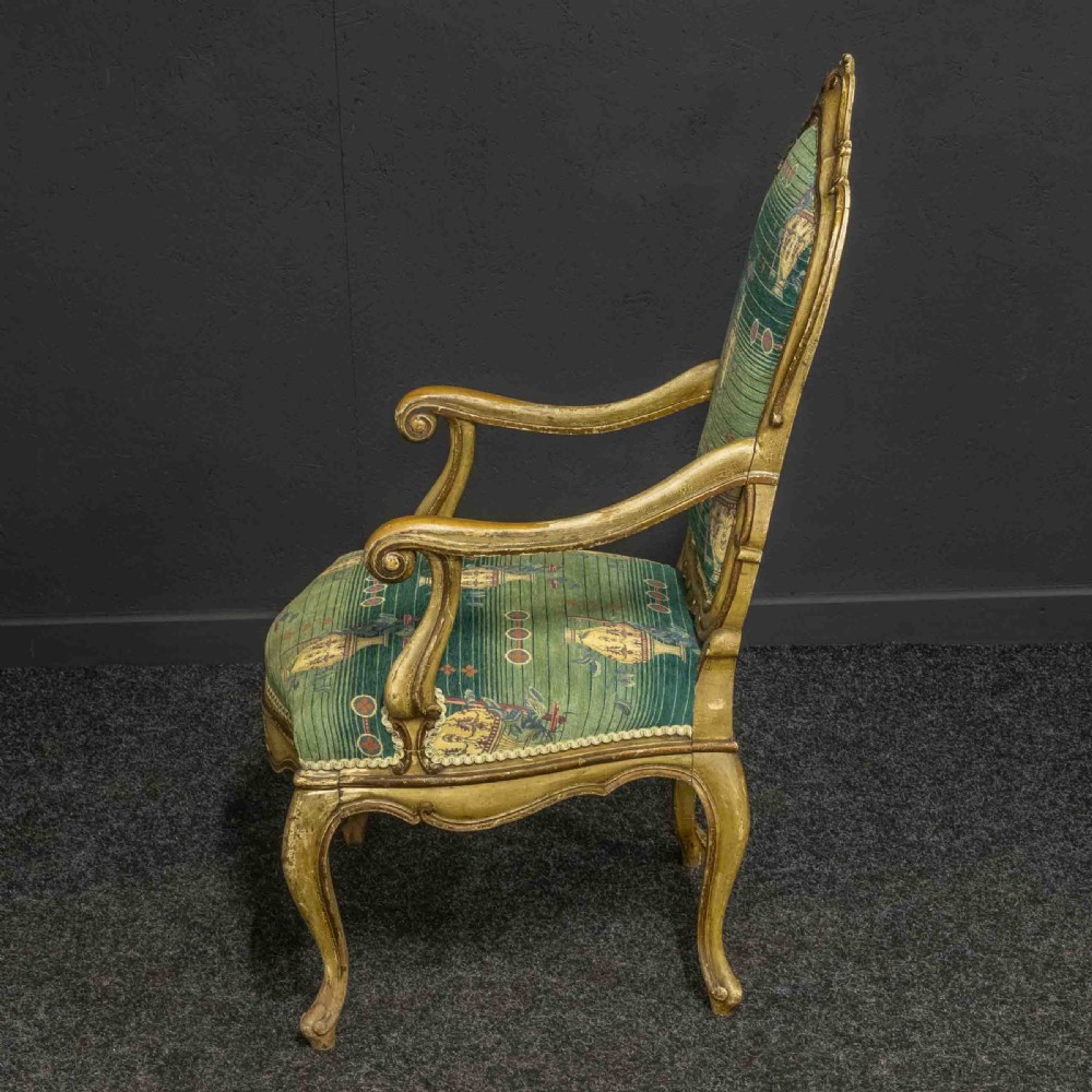 A 19th-century French giltwood fauteuil open armchair featuring carved shell motifs, cabriole legs, and patterned green upholstery. View X