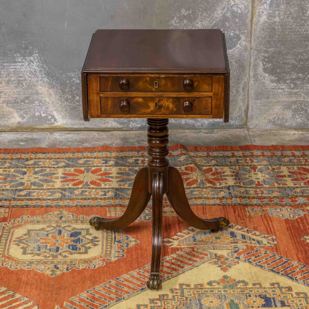 A Regency mahogany drop-leaf worktable featuring two drawers with wooden knobs, a turned pedestal column, and tripod legs with brass paw feet. View II