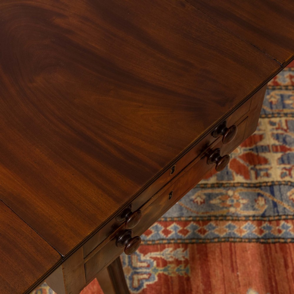 A Regency mahogany drop-leaf worktable featuring two drawers with wooden knobs, a turned pedestal column, and tripod legs with brass paw feet. View V