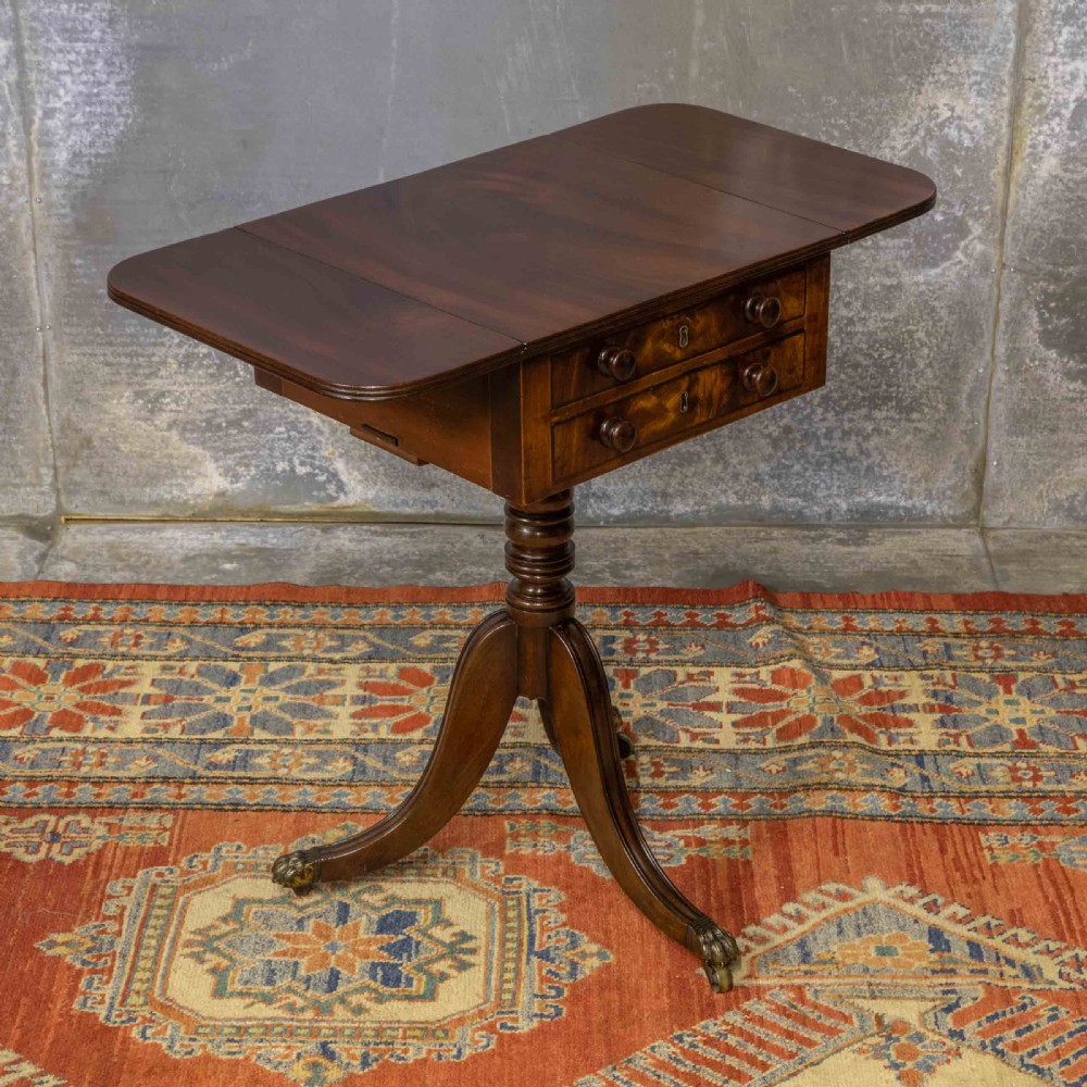 A Regency mahogany drop-leaf worktable featuring two drawers with wooden knobs, a turned pedestal column, and tripod legs with brass paw feet. View IX