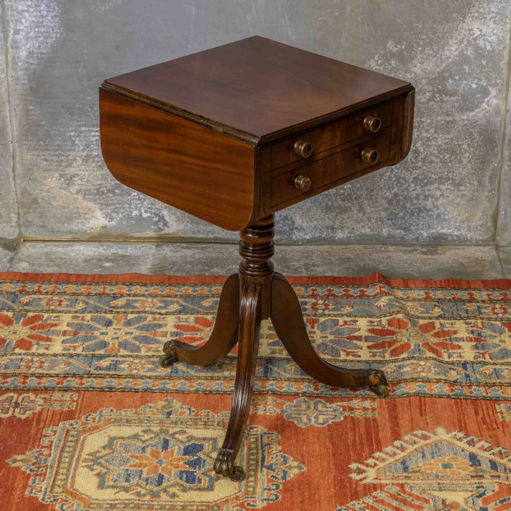 A Regency mahogany drop-leaf worktable featuring two drawers with wooden knobs, a turned pedestal column, and tripod legs with brass paw feet. View XI