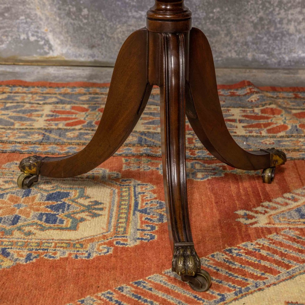 A Regency mahogany drop-leaf worktable featuring two drawers with wooden knobs, a turned pedestal column, and tripod legs with brass paw feet. View XVI