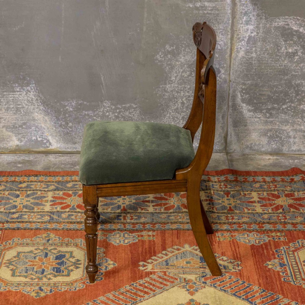 A set of six William IV mahogany dining chairs featuring carved top rails, turned front legs, and green velvet upholstered seats. View III