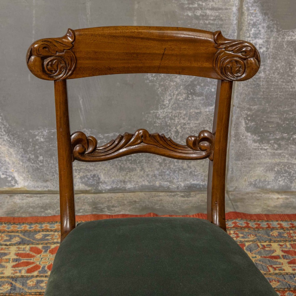 A set of six William IV mahogany dining chairs featuring carved top rails, turned front legs, and green velvet upholstered seats. View IX