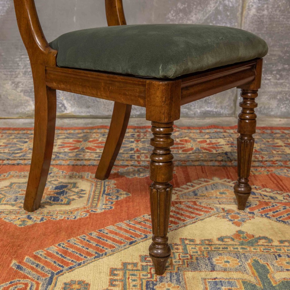 A set of six William IV mahogany dining chairs featuring carved top rails, turned front legs, and green velvet upholstered seats. View XI