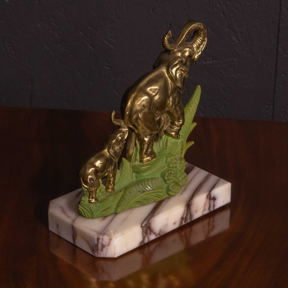 A pair of Art Deco brass elephant bookends with green painted foliage bases mounted on white veined marble plinths holding two books. View VII