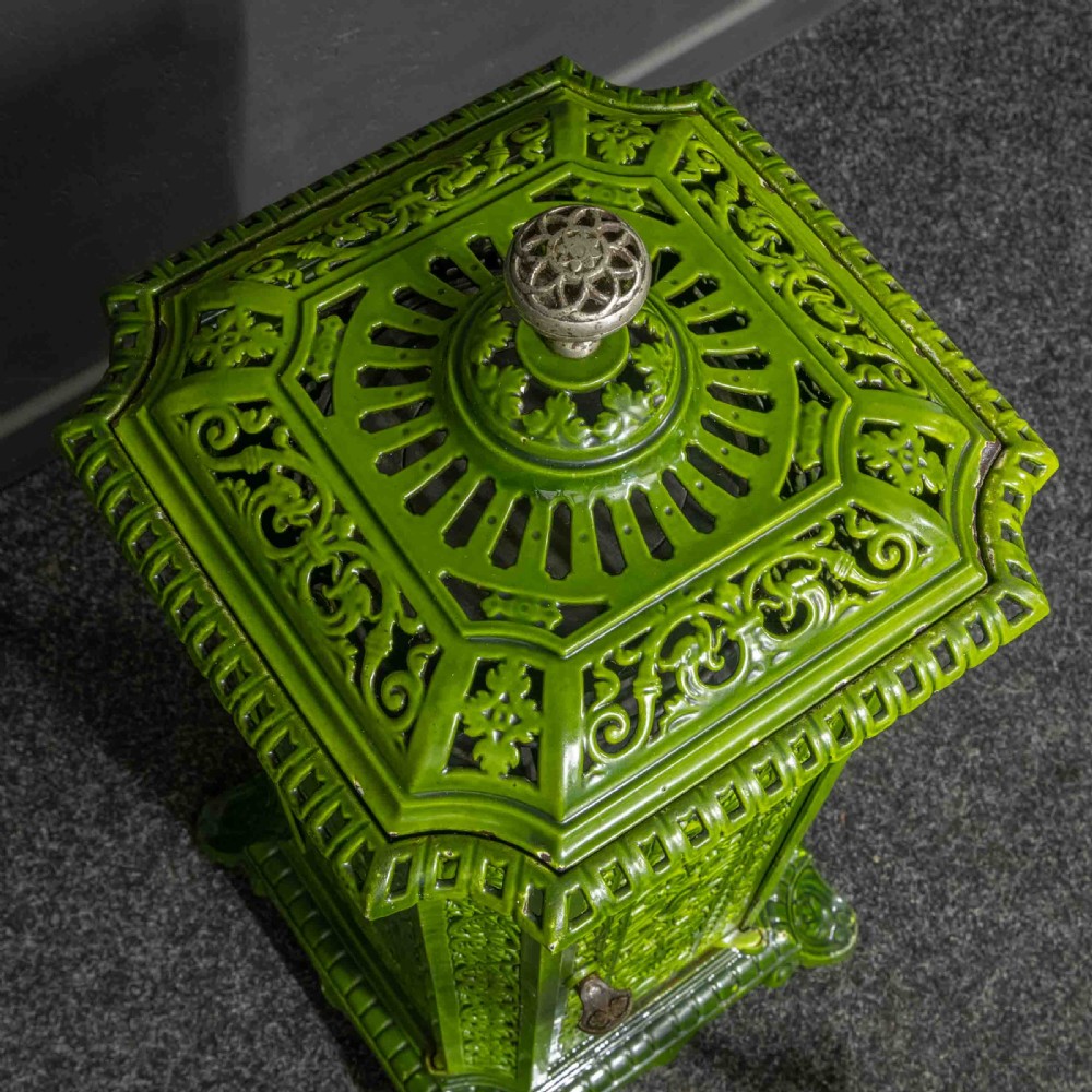 A tall rectangular green enamelled cast iron stove with elaborate openwork pierced filigree patterning and scrolled feet. View III