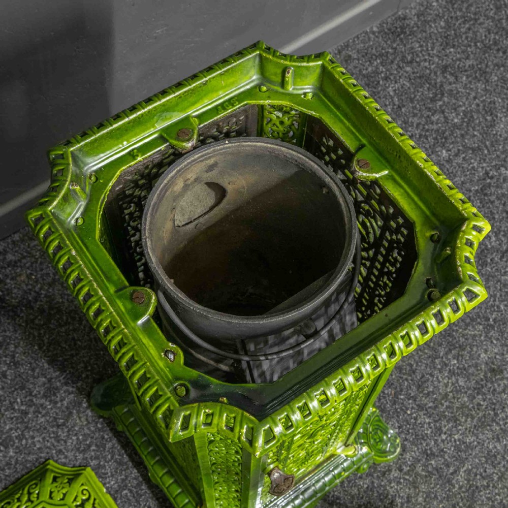 A tall rectangular green enamelled cast iron stove with elaborate openwork pierced filigree patterning and scrolled feet. View VII