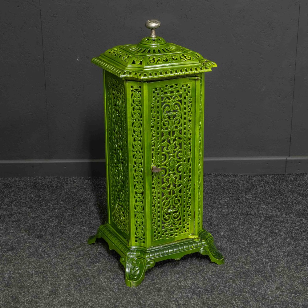 A tall rectangular green enamelled cast iron stove with elaborate openwork pierced filigree patterning and scrolled feet. View XIII