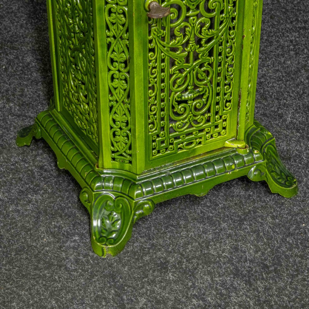 A tall rectangular green enamelled cast iron stove with elaborate openwork pierced filigree patterning and scrolled feet. View XIV