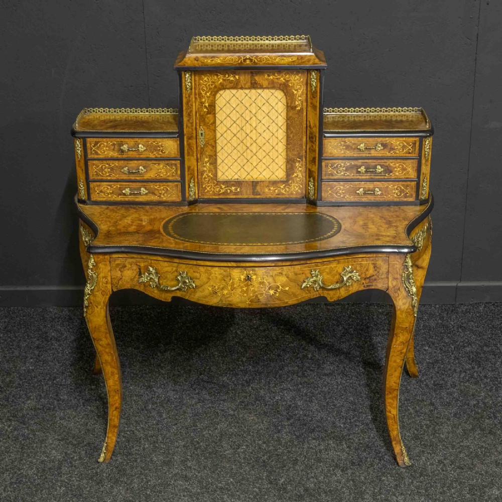 A Victorian burr walnut bonheur de jour featuring floral marquetry inlays, gilt brass mounts, cabriole legs, and a green leather writing surface. View III